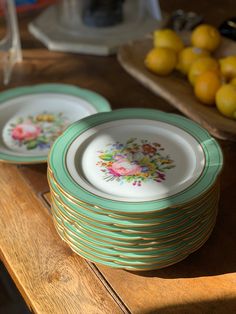 several plates stacked on top of each other with fruit in the back ground behind them