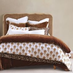 a bed with brown and white pillows on it