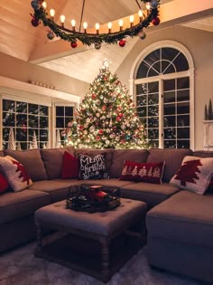 a living room with a christmas tree in the corner and lights hanging from the ceiling