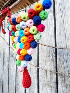 there is a multicolored crochet decoration hanging from the side of a building