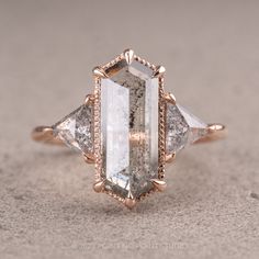 an engagement ring with three stone accents on the side and two diamonds in the middle