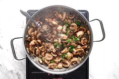 a pan filled with mushrooms on top of a stove