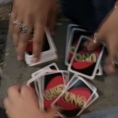 several people are playing cards together on the ground with their hands holding onto each other