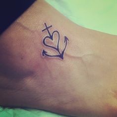 a small tattoo on the foot of a person with a cross and heart in it