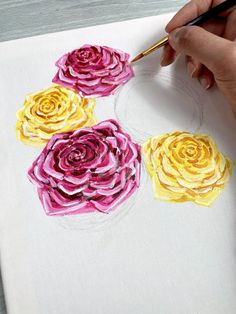 someone is drawing flowers with colored pencils on paper