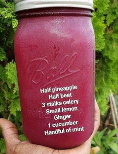 a hand holding a mason jar filled with purple liquid and instructions on how to use it