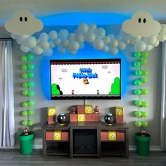 a video game themed party with balloons and mario kart on the tv screen in front of it