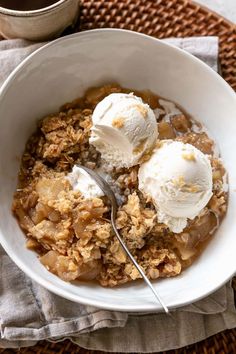 two scoops of ice cream sit in a bowl of apple crisper cobbler