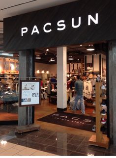 a store front with people walking in and out of the doors, on which there is a sign that says pacsun