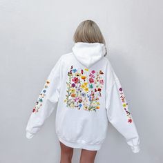 Elevate your style with this delightful and vibrant zip hoodie featuring a stunning wildflower design on the back and sleeves. Each hooded sweatshirt is carefully crafted to infuse a touch of nature into your wardrobe. The colorful wildflowers burst with life, creating a sense of warmth and joy. This hoodie is a perfect blend of style and comfort, making it an ideal addition to your wardrobe. Whether you're going for a walk in the park, a cozy evening in, or simply want to express your love for Flower Embroidered Hoodie, Colorful Wildflowers, Wildflower Design, Nature Enthusiast, Floral Pullover, Floral Hoodie, Boho Cottagecore, Logo Vintage, Embroidered Hoodie