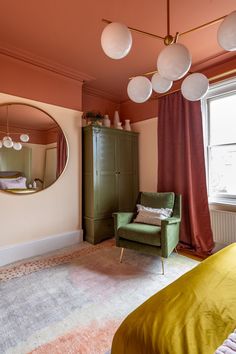 a bedroom with pink walls and green furniture