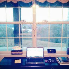 an open laptop computer sitting on top of a desk in front of a large window