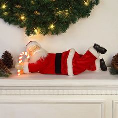 a santa clause laying on top of a white mantle