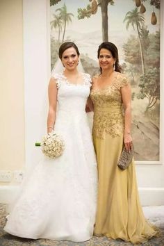 two women standing next to each other in front of a wall with paintings on it