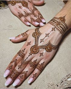 two hands with henna tattoos on them