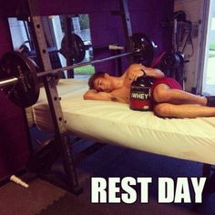 a man laying on top of a bench next to a barbell