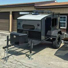 an off - road vehicle parked in front of a building with garage doors on the side