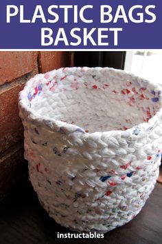 a white plastic basket sitting next to a brick wall