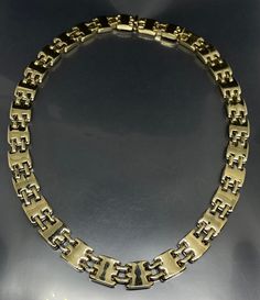 This vintage St John necklace is a one-of-a-kind piece that is perfect for any collector of vintage and antique jewelry. The collar features a modernist design and is made from heavy gold-tone metal with a push lock closure, making it a unique addition to your jewelry collection. The necklace is adjustable with a length of 16-17 inches and is suitable for both men and women. It is signed by St John and is a true statement piece that will add a touch of glamour to any outfit. The main stone is no Gold Metal Chain Necklace With Polished Finish, Modern Gold Chain Necklace With Polished Finish, Gold Chain Necklace With Polished Finish, Vintage Gold Box Chain Necklace, Vintage Gold Necklace With Box Chain, Modernist Gold Metal Jewelry, Antique Gold Necklace For Formal Occasions, Modern Gold Necklace For Formal Occasions, Vintage Formal Necklace With Box Chain