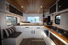 the interior of a small camper with bunk beds and kitchen countertop space in it