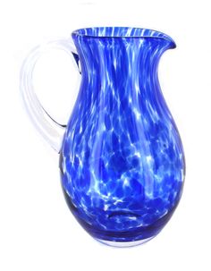 a blue glass pitcher sitting on top of a white table