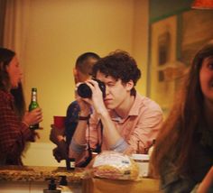 a group of young people standing around a kitchen counter