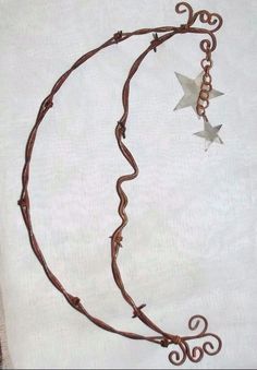 a piece of art that looks like a crescent with stars hanging from it's sides