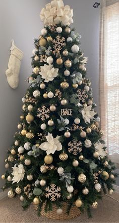 a decorated christmas tree with white and gold ornaments