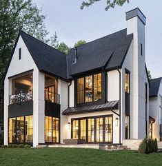 a large white house sitting on top of a lush green field