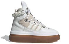 As part of an Alpine-themed collection with Beyonce's athleisure brand, the Ivy Park x adidas women's Super Sleek Boot 'Icy Park' is a striking sneaker-boot made for the mountains. The high-cut collar and premium leather and suede upper are immediately eye-catching, while the metal hardware and elastic bungee cord add to the mountaineering aesthetic. The towering silhouette is mounted on an exaggerated gum rubber sole unit, featuring a herringbone traction pattern for reliable grip even on the m Adidas Ivy Park Super Sleek Price, Adidas Ivy Park, Adidas Sleek, Adidas Super, Athleisure Brands, White Core, Ivy Park, Hot Sneakers, Womens Athletic Shoes