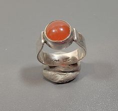 simple sterling silver ring accented with a carnelian cabochon large size cabochon ring size 9.5 usa marked silver anf j & gm the round stone is glued into the setting 20 % restocking fee! Modern Silver Rings With Cabochon, Silver Rings With Polished Carnelian, Silver Carnelian Rings With Polished Finish, Silver Carnelian Ring Stamped 925, Sterling Silver Cabochon Ruby Ring, Adjustable Silver Carnelian Rings, Silver Carnelian Oval Cabochon Jewelry, Sterling Silver Rings Simple, Carnelian Ring