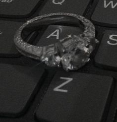 a diamond ring sitting on top of a computer keyboard