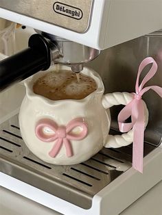 a coffee maker with a pink bow on it