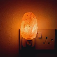 a light that is sitting on a wall next to a electrical outlet in a room