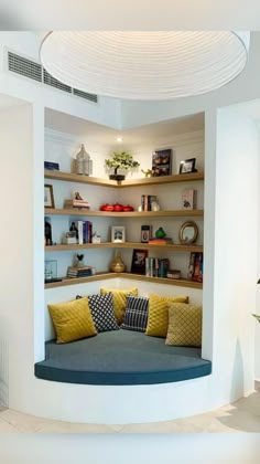 a living room filled with lots of furniture and shelves next to a potted plant