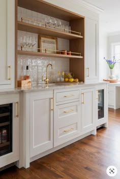 a kitchen with white cabinets and gold trim on the upper half of the cabinet doors