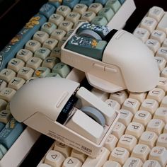 two computer mice sitting on top of a keyboard