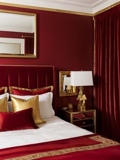 a bedroom with red walls and gold accents