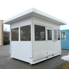 a small white building sitting in the middle of a parking lot