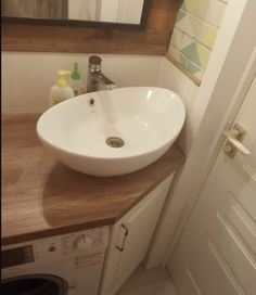 a white sink sitting on top of a wooden counter