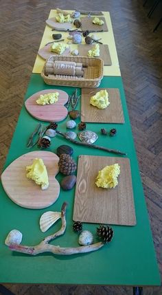 the table is set up with pine cones, spoons, and other food items