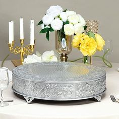 a white table topped with a cake covered in frosting next to yellow and white flowers