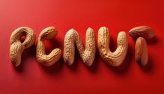 the word peanuts spelled with nuts on a red background in an artistic way that makes it look like they are made out of wood