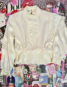 "Gorgeous Vintage Blouse for any Special Occassion. Pre Loved Great Condition No Stains, Holes or Snags Vintage 80s 90s Brand: SilverCord Vanilla Cream Silky Blouse Padded Shoulders High Neckline Floral Lace Trims at Neckline down to Waist Lace Trims as seen on the Pics. Long Sleeves/Silky Satin Waist with Side Buttons Back Button Closure Size Approx. Size Medium Large Check the Measurements Below Measured Laying Flat Shoulder to Shoulder: 16 1/2\" Armpit to Armpit: 43\" Around Sleeves: 23 1/2\" Preppy Tops, Womens Pleated Skirt, Pink Trousers, High Neck Blouse, Wool Mini Skirt, Cream Blouse, Silky Blouse, Vintage Blouse, Black White Dress