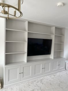 an entertainment center with built - in shelves and a flat screen tv on the wall