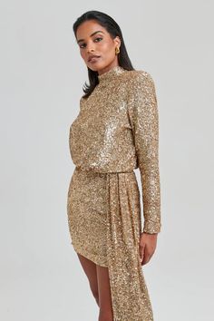 a woman wearing a gold sequin dress