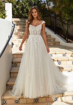 a woman in a wedding dress standing on some steps