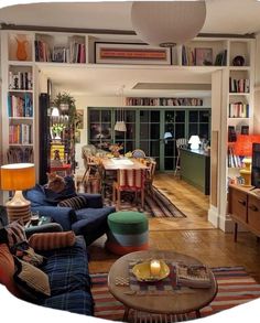 a living room filled with lots of furniture and bookshelves on top of it