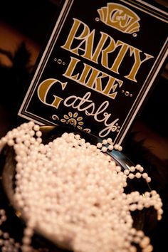 a party like garbry sign sitting on top of a bowl filled with pearls