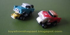 two toy cars sitting side by side on a green surface